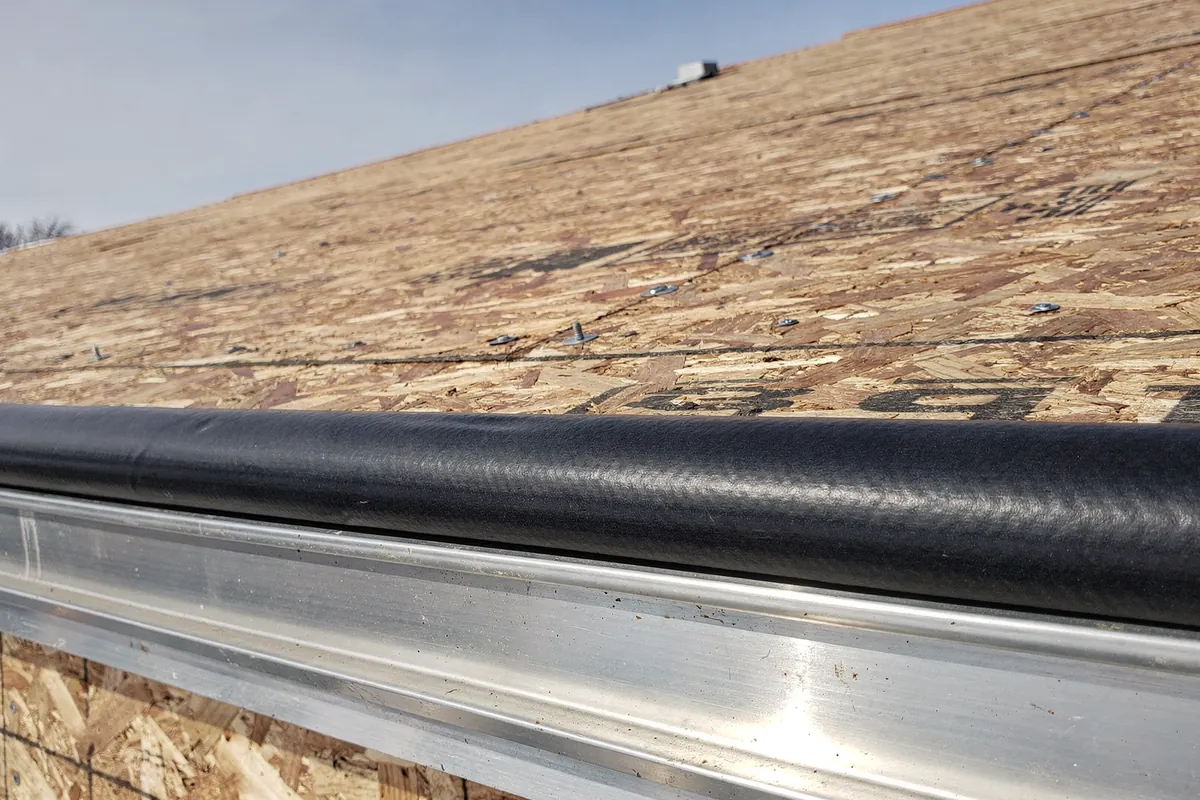 A new aluminium drip edge and gutter along the eave of a Michigan roof
